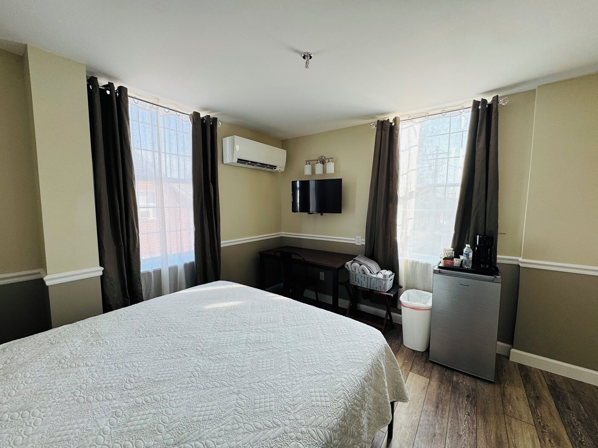 Une chambre d’hôtel équipée d’un lit, d’un bureau, d’une télévision et d’un réfrigérateur.