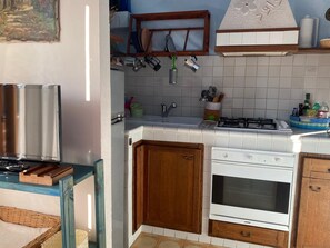 A kitchen with white cabinets, a gas stove, a built-in oven, and a microwave. - Pisa Centro a 10-minute walk, private parking, Wi-FI (Pisa)