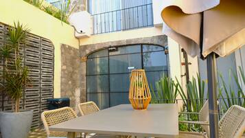 A patio with a table and chairs, a potted plant, and a decorative lantern.