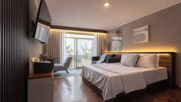A modern hotel room with a bed, a desk, a chair, and a television.