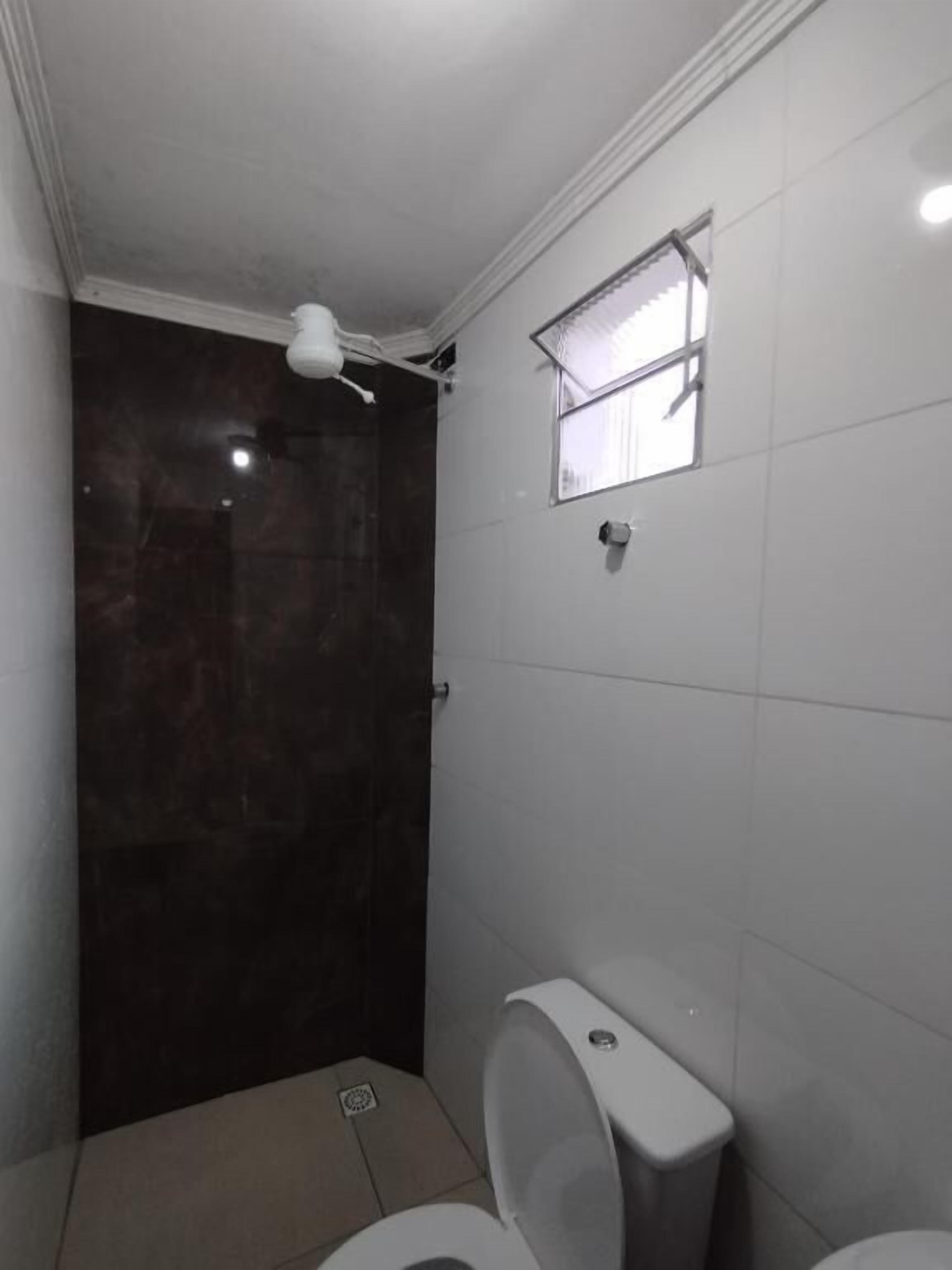 Een douche, handdoeken, zeep, toiletpapier