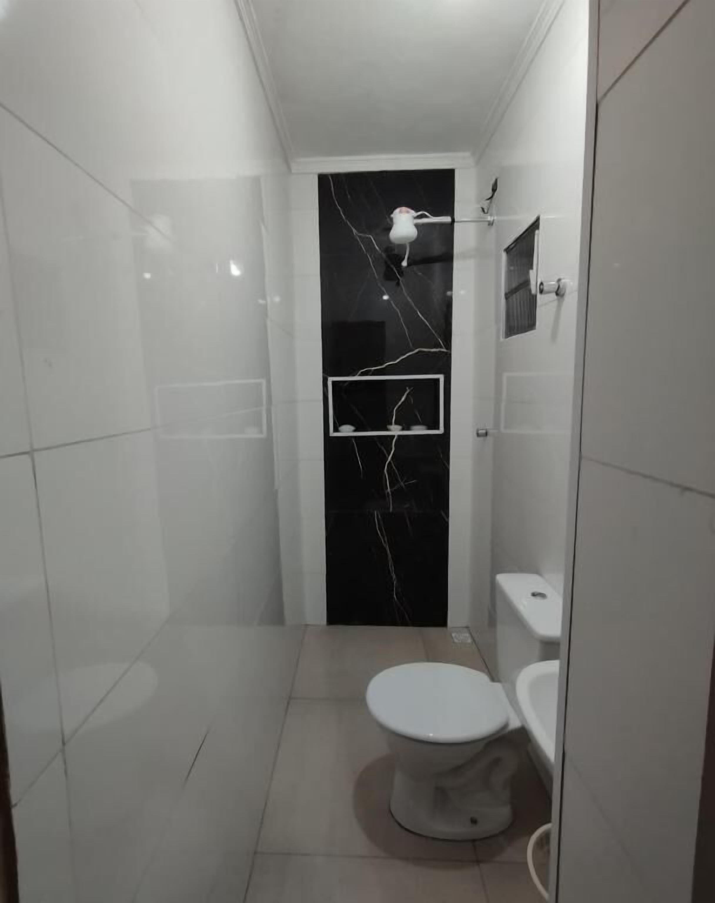 A small, modern bathroom with a toilet, bidet, and a mirror.