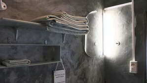 Un baño con toallero, un cartel y zona de ducha.
