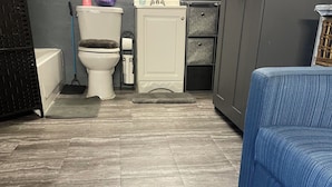 A bathroom with a toilet, sink, and shower area. - Cozy 1-bedroom studio tiny home experience (Orlando)