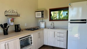 Una cocina equipada con microondas, estufa, horno, fregadero y refrigerador.