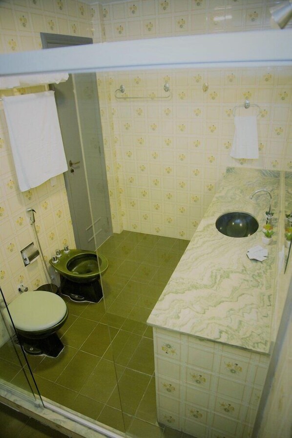 A bathroom with a toilet, sink, and shower. - Pousada Hygge House Rio (Rio de Janeiro)
