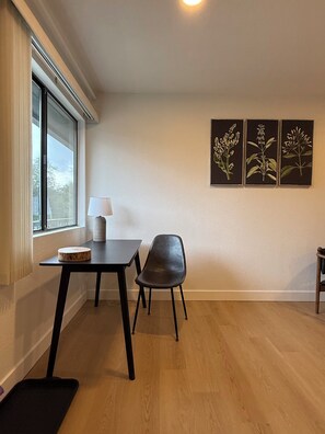 A room with a table, a chair, a lamp, and three botanical artwork pieces on the wall. - Granite Ridge (Oakhurst)