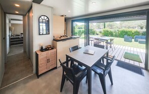 A modern kitchen with a dining area, large windows, and a view of the garden. - Cozy home in Olonzac with heated swimming pool (Olonzac)