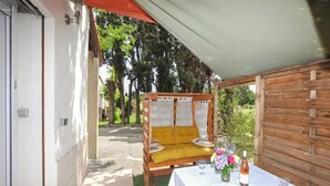 Un espacio al aire libre cubierto con una mesa, una botella de vino y una copa.