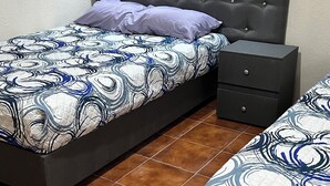 Ein Schlafzimmer mit zwei Betten, einem Nachttisch und einer Kommode.