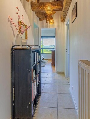 A hallway with a bookshelf, a radiator, and a view to the outside. - Le Clos des Vignes - VERZE (VERZE)