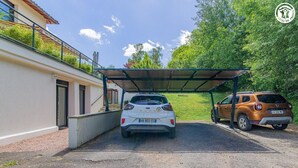 A gravel driveway leading to a covered parking area with two cars parked. - Le Clos des Vignes - VERZE (VERZE)