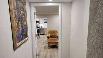 A hallway with a dining area, a kitchen, and a living room.