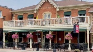 A two-story building with a balcony and a covered entrance area. - Charming Streetsville 2BR Suite-Parking & Laundry (Mississauga)
