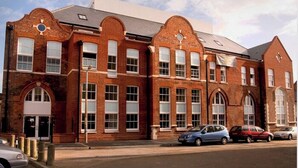 A red brick building with multiple windows and a flat roof.