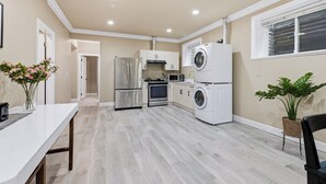A modern kitchen with stainless steel appliances, a built-in oven, and a washing machine. - 3BR Suite near White Rock Beach • Pool & BBQ (Surrey)