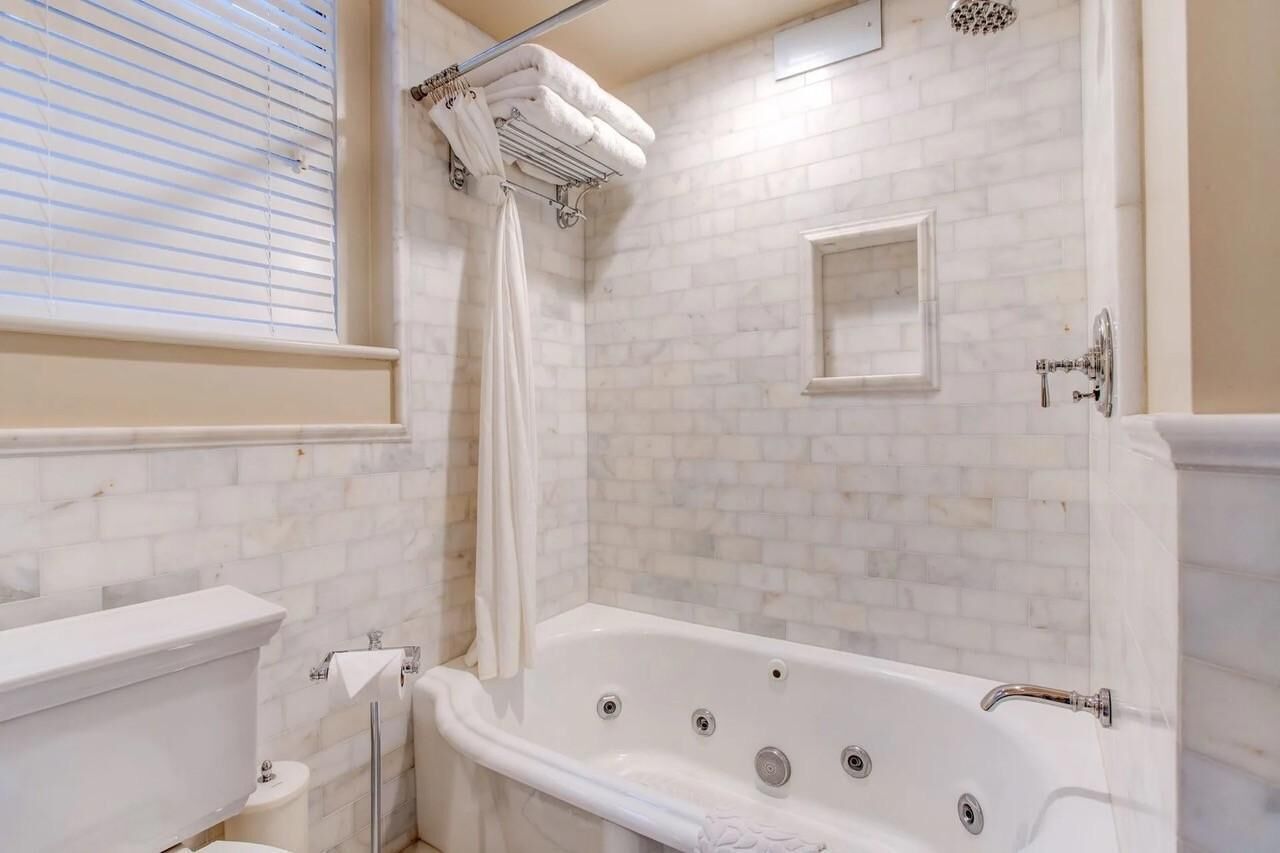 Une salle de bain avec une baignoire blanche, une douche et des toilettes.