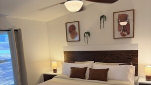 A bedroom with a bed, ceiling fan, bedside lamps, and artwork on the wall. - Lakefront 3BR/2BATH with Private Dock on 3/4 Acre in terrific Nocona with AC (Nocona)