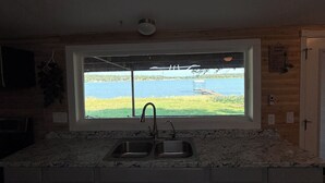 A kitchen with a large window, a sink, and cabinets. - Lakefront 3BR/2BATH with Private Dock on 3/4 Acre in terrific Nocona with AC (Nocona)