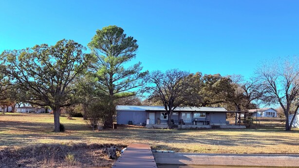 A wooden dock leading to a calm body of water with a clear sky. - Lakefront 3BR/2BATH with Private Dock on 3/4 Acre in terrific Nocona with AC (Nocona)