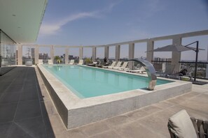 A rooftop pool with a clear view of the city skyline, surrounded by lounge chairs and a modern architectural design. - Mr. W : Exceptional apartment 2BR Cauda (Guadalajara)