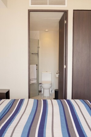 A hotel room with a bed, a door leading to a bathroom, and a small table. - Mr. W : Exceptional apartment 2BR Cauda (Guadalajara)