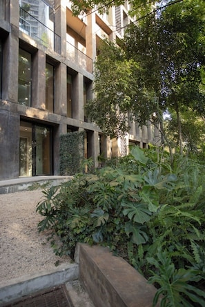A modern building with large windows and a courtyard with dense foliage. - Mr. W | Modern 2 bedroom apartment in Providencia (Zapopan)