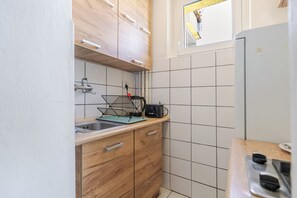 Eine kompakte Küche mit Holzschränken, einem Spülbecken und einem Fenster mit Blick.