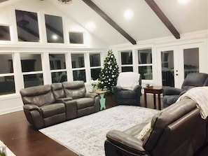 Un salon avec un canapé en cuir, une table basse et un sapin de Noël.