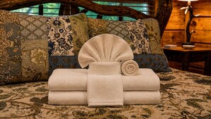 A bed with a floral-patterned bedspread, a wooden headboard, and a bedside lamp. - Creekside Green - Firepit | Gazebo alongside creek | pond (Cherry Log)