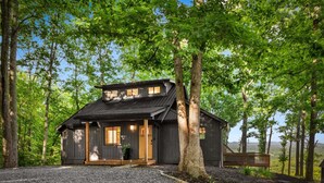 A cabin with a sloped roof, wooden exterior, and a porch with a bench. - Blue Moon Rise - Pet Friendly | Mountain View | Hot Tub (Blue Ridge)