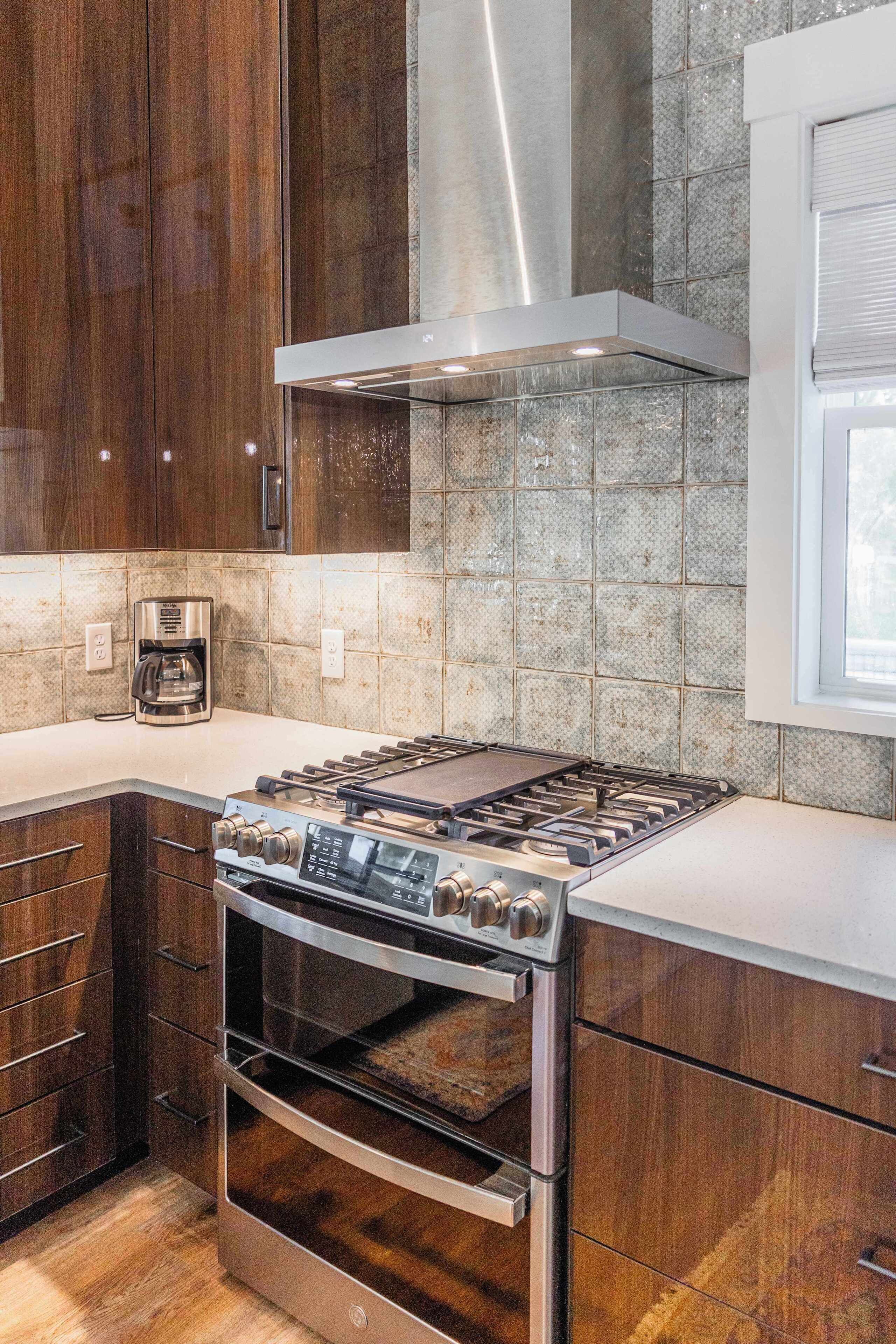 A modern kitchen with a stainless steel stove, oven, and a coffee maker on the counter.