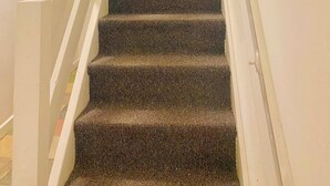 A staircase with carpeted steps, white handrails, and a ceiling light. - Kensington Studio, 2nd-Floor City Base (Kensington)