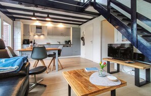 Ein zeitgemäßer Wohnraum mit Essbereich, Küche und Treppe.