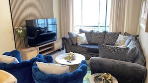 A living room with a sofa, armchairs, a coffee table, and a TV. - Cape Town Urban Elegance on Long Street | Unbeatable Table Mountain View’s (Cape Town)