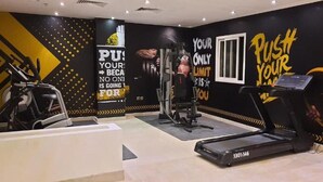 Een sportschool met trainingsapparatuur, inspirerende muurdecoratie en een loopband.