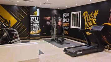 A gym with exercise equipment, motivational wall art, and a treadmill.