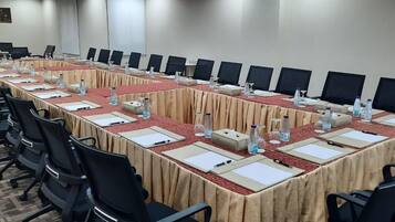 A conference room with a long table, chairs, water bottles, and nameplates.