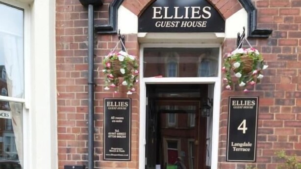 Un edificio de ladrillo con un letrero que dice 'Ellies Guest House' y el número de puerta '4 Langdale Terrace'.