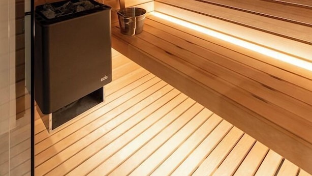 A sauna with wooden slats, a bench, and a heater. - Hortenberg Homes (Bolzano)