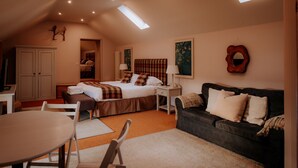 A bedroom with a bed, a nightstand, a dresser, a window, and a couch. - The Loft On The Yorkshire Dales (Ripon)