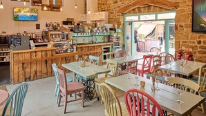 A rustic interior with wooden furniture, a bar area, and a stone wall.