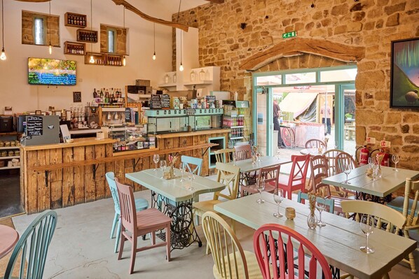 Un intérieur rustique avec des meubles en bois, un coin bar et un mur en pierre.