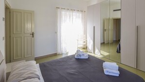 Une chambre à coucher avec un lit, une armoire et un miroir.