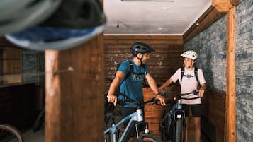 Un interior de madera con una pared de piedra, una lámpara en el techo y dos bicicletas.