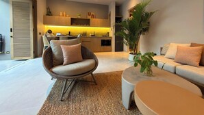 A modern living room with a sofa, a chair, a coffee table, and a large plant. - Sin Nombre Homes  (Badung)