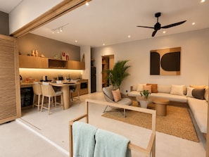 Um espaço de estar moderno com cozinha, sala de jantar e área de estar.