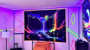 Un dormitorio con cama, televisión en la pared, escritorio y silla.