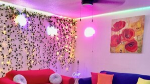 Una sala moderna con un sofá rojo y azul, una mesa de centro y una alfombra colorida.