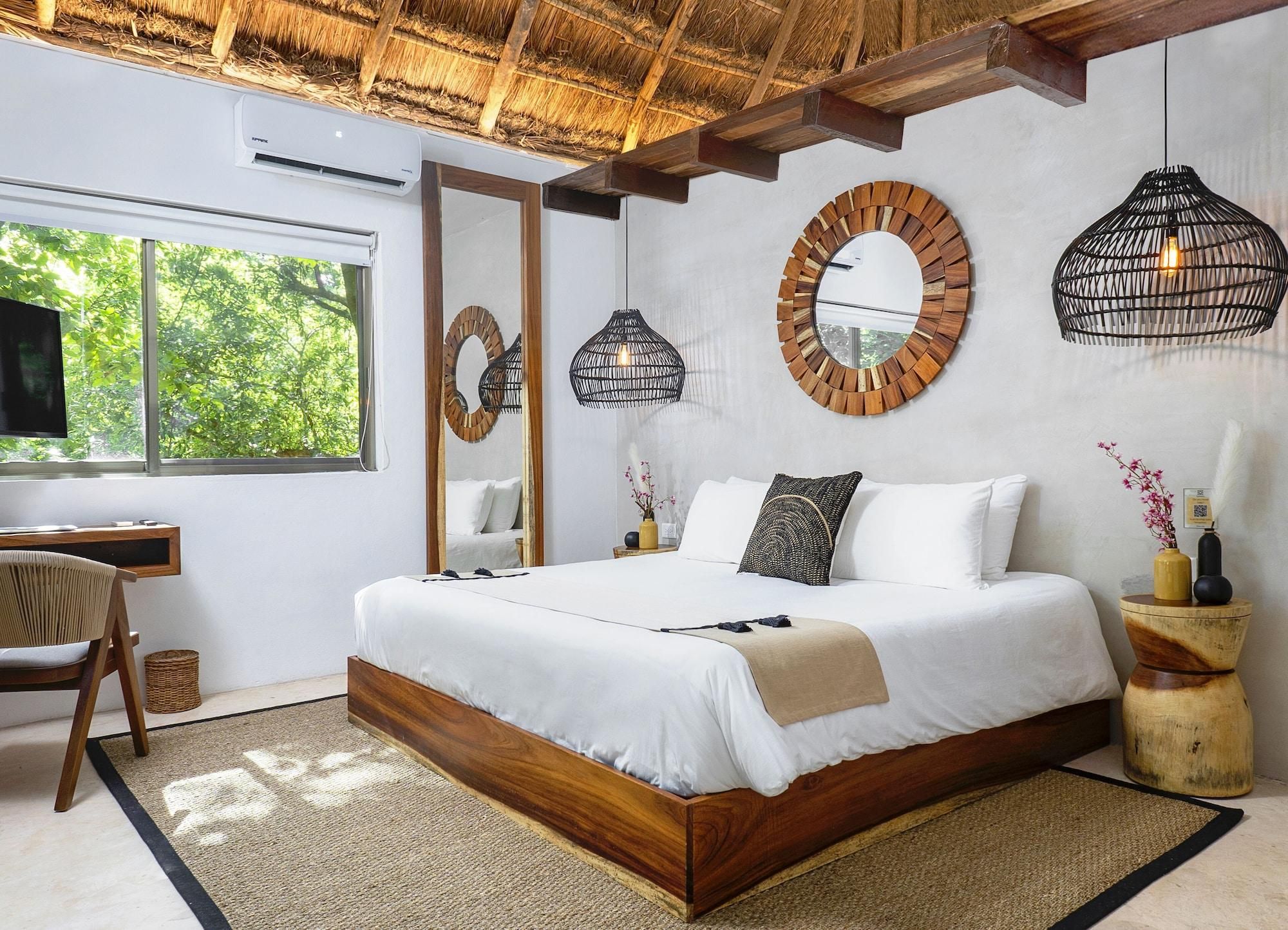 A modern bedroom with a large bed, a desk, and a TV.